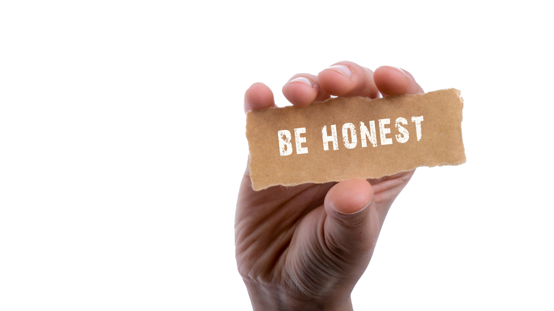 A hand holding a piece of torn paper with the phrase 