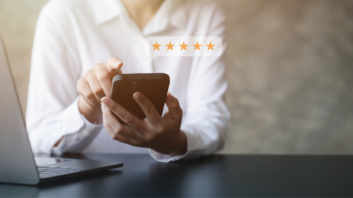 A woman using her phone to rate something with 5 stars
