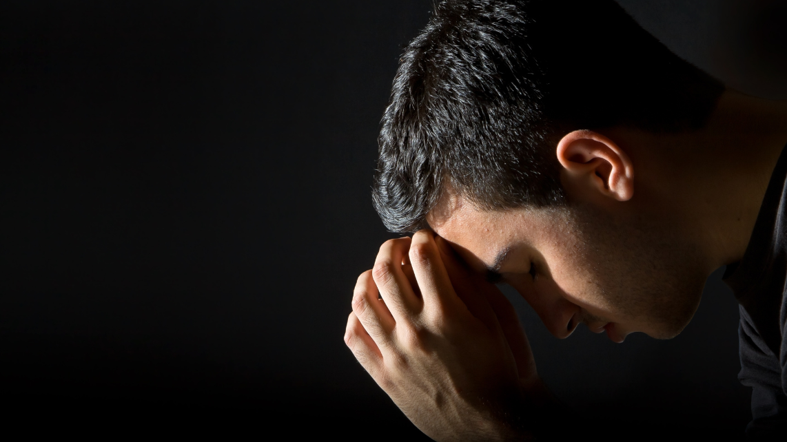A man praying in the dark